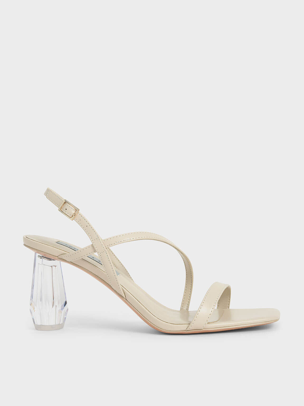 Charles & Keith Faux Leather Chalk white colour strappy sandals, featuring a see-through architectural heel that will turn heads in a crowd. Thin strap over the toe, across the foot and fastening in with an adjustable back strap that ensures a comfortable fit. 
