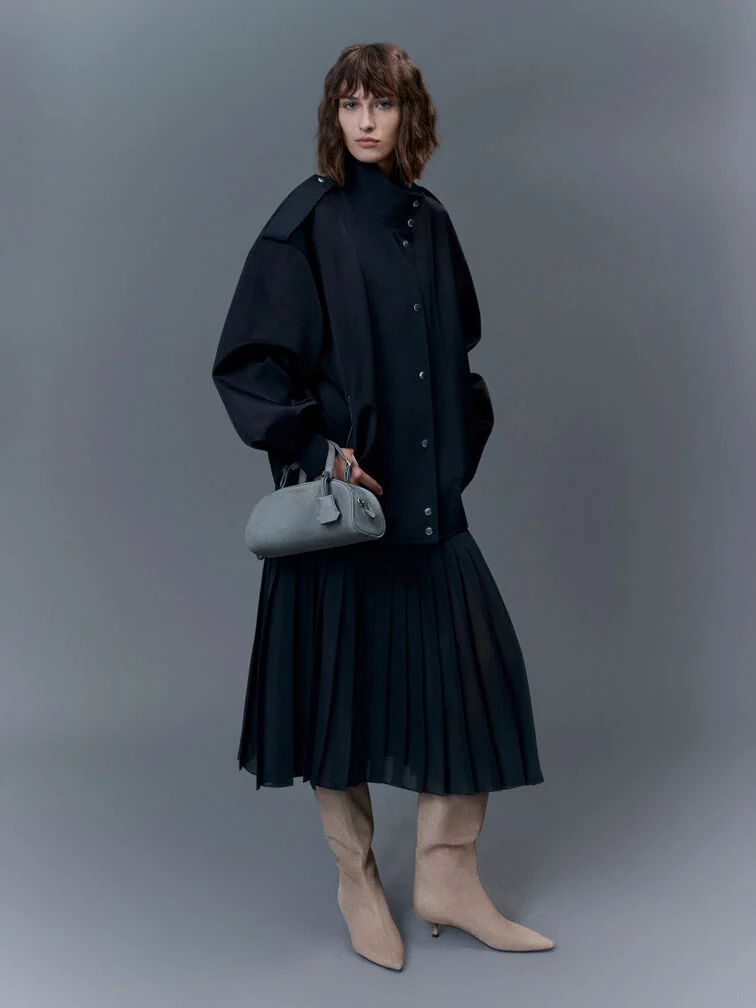 A black maxi dress paired with an oversized jacket and boots for a winter-appropriate look. 