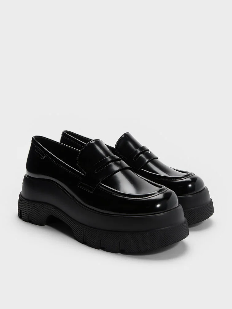 Black penny loafers set atop thick platform soles