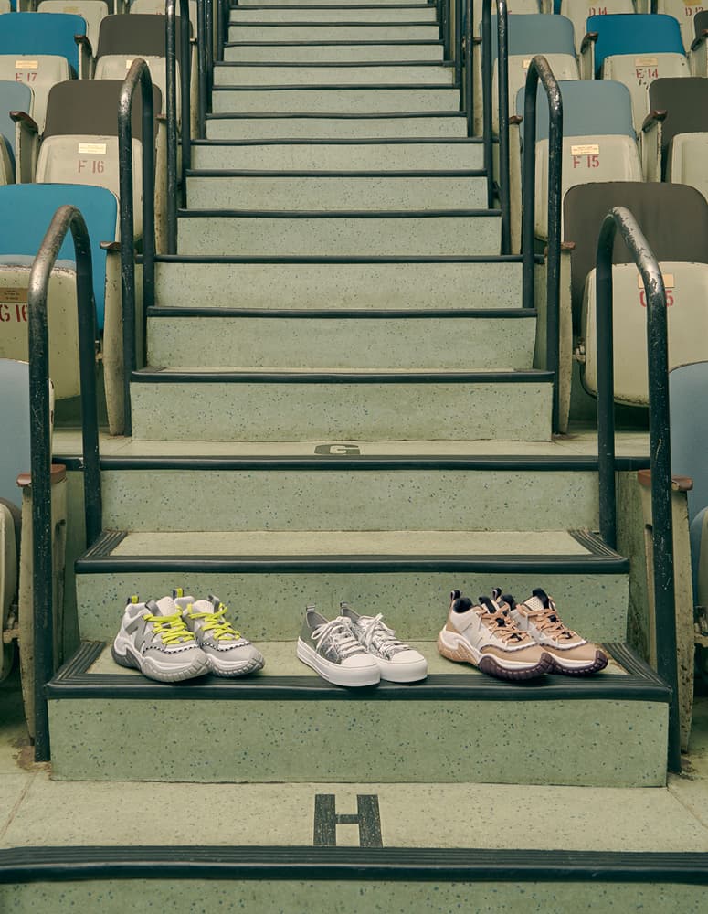 Fashionable chunky sneakers lined up on a step of a flight of stairs.