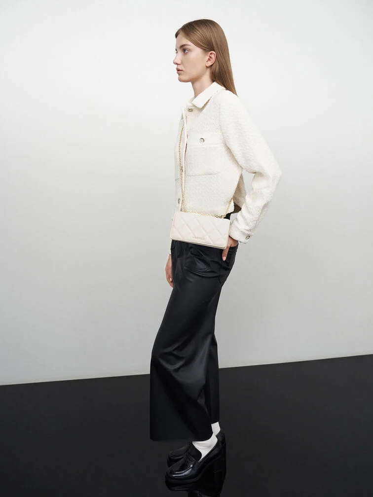 A cream jacket styled with black tailored pants and black loafers for a striking black-and-white outfit.