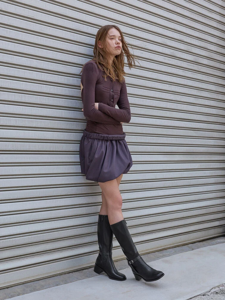 Pair edgy buckled boots with soft feminine pieces like a bubble skirt to create stylish contrast. 