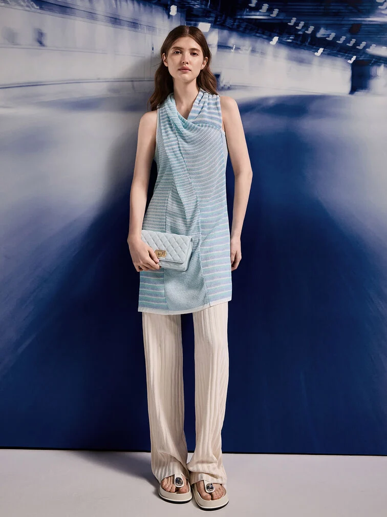 Blue quilted push-lock clutch paired with a matching knit tunic and loose pants for a daytime ensemble.