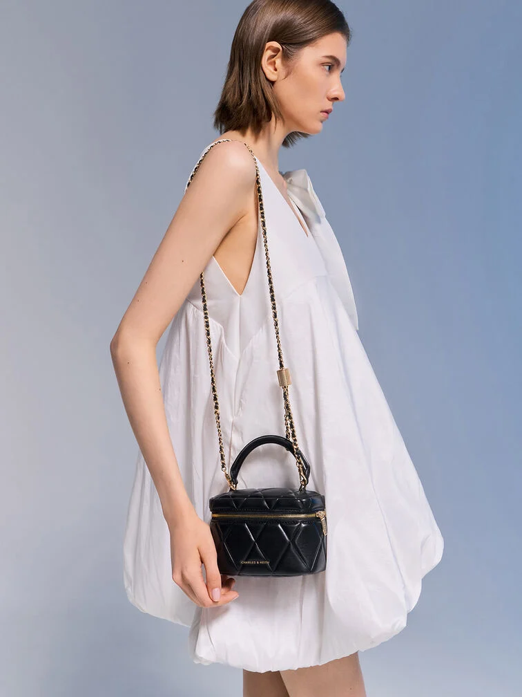 White bubble mini dress paired with a classic black quilted top-handle vanity bag. 