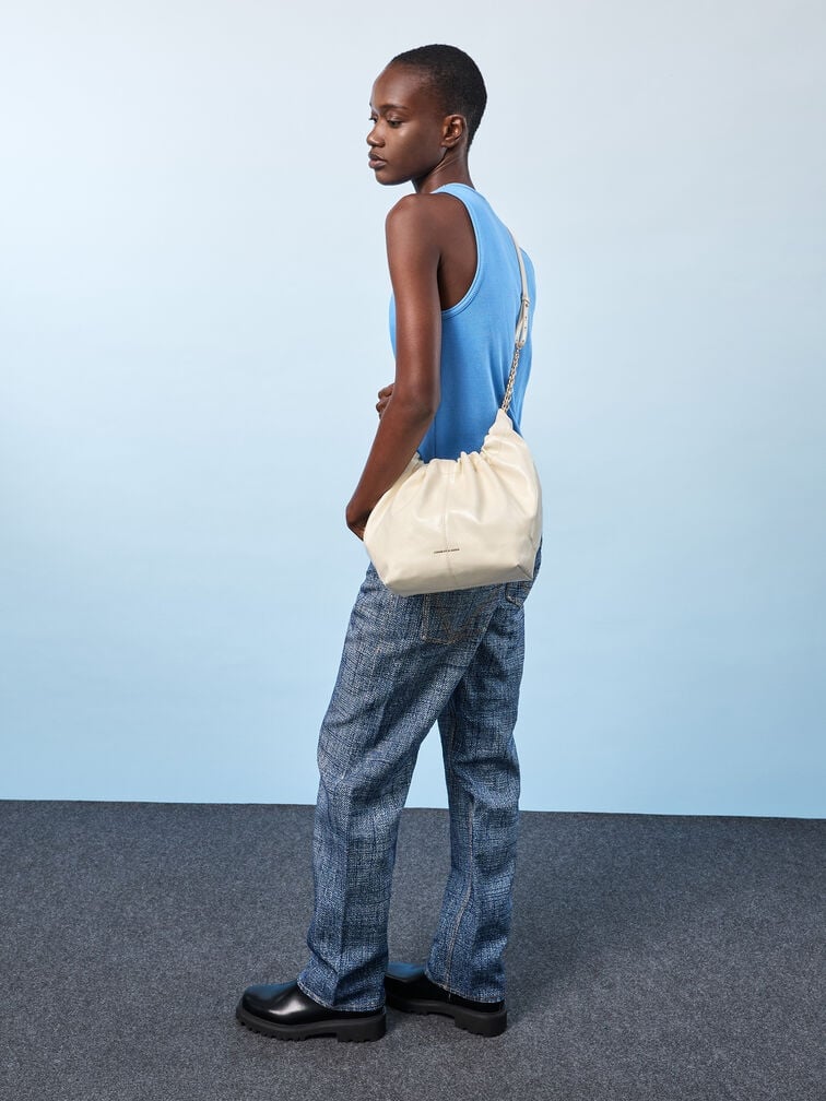 A slouchy crossbody bag worn low at the hip for a cool and effortless vibe