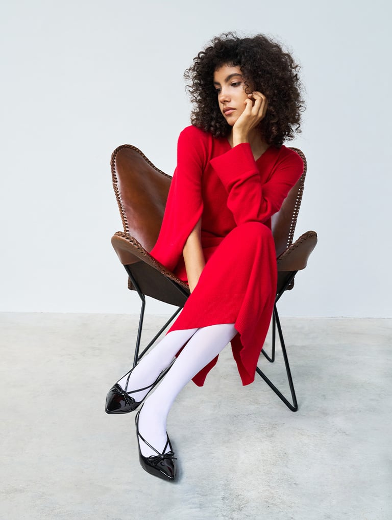 Women’s patent cut-out bow kitten-heel pumps in black, on model with red dress – CHARLES & KEITH