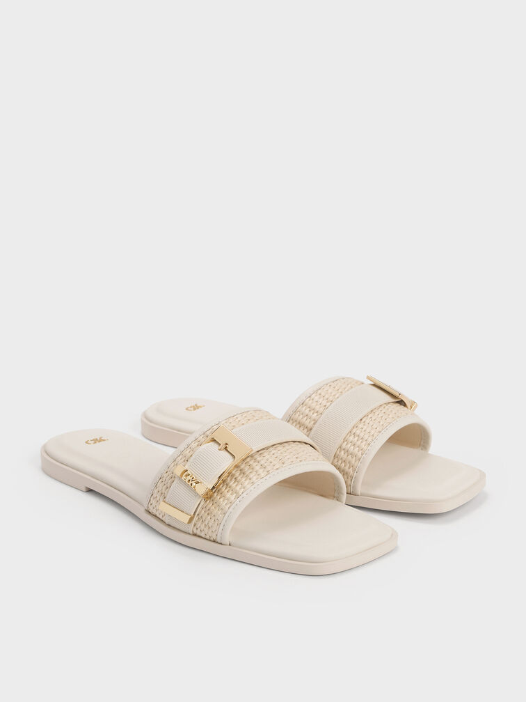 White flat sandals with buckle-detailed raffia straps.