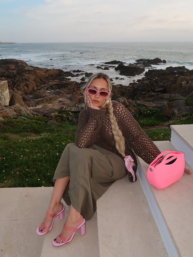 Women’s Cocoon Curved Handle Bag in pink; Fia Geometric Heel Mules in light pink; Gabine Recycled Acetate Oval Sunglasses in violet, as seen on Sofia Coelho - CHARLES & KEITH
