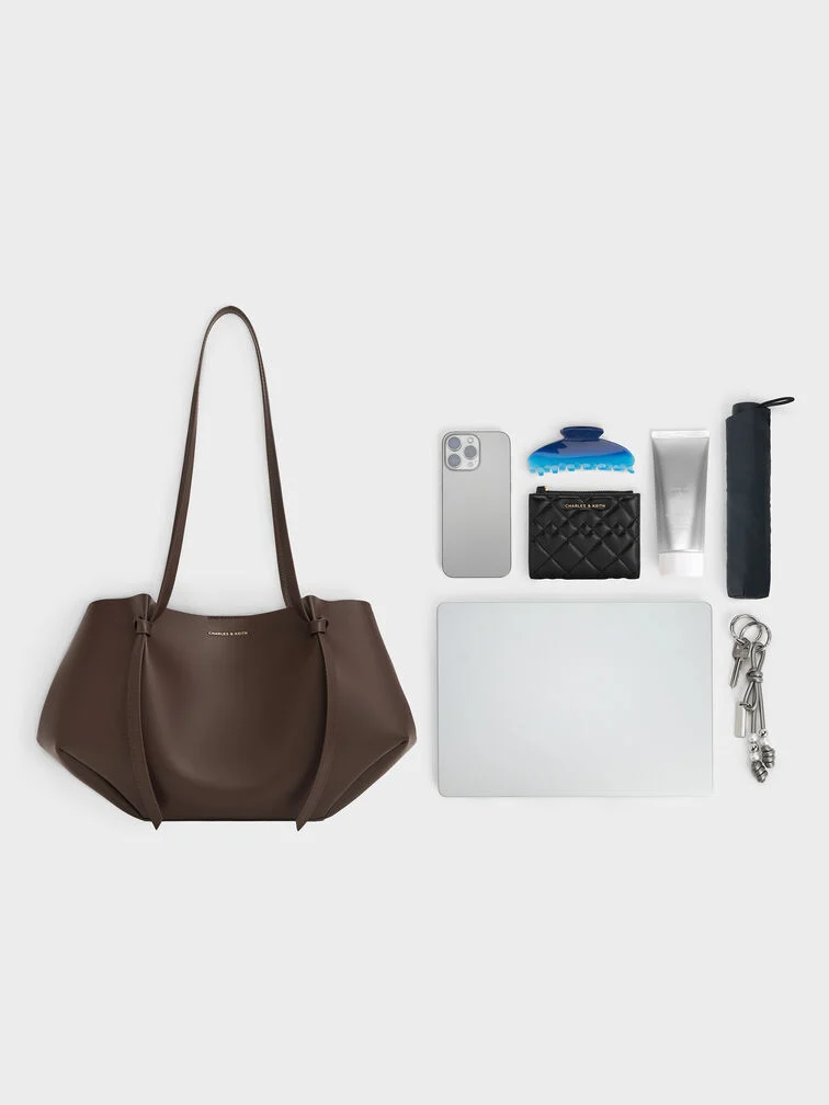 The regular Calla tote bag with the side flaps folded in can comfortably fit an 11” ipad, phone, umbrella and other daily essentials