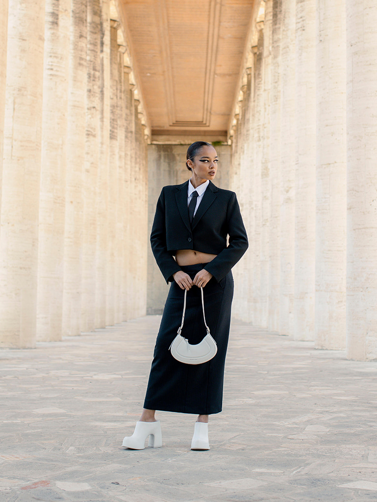 Women’s Petra curved shoulder bag and Pixie platform mules in white, as seen on Mikaela Neaze Silva – CHARLES & KEITH