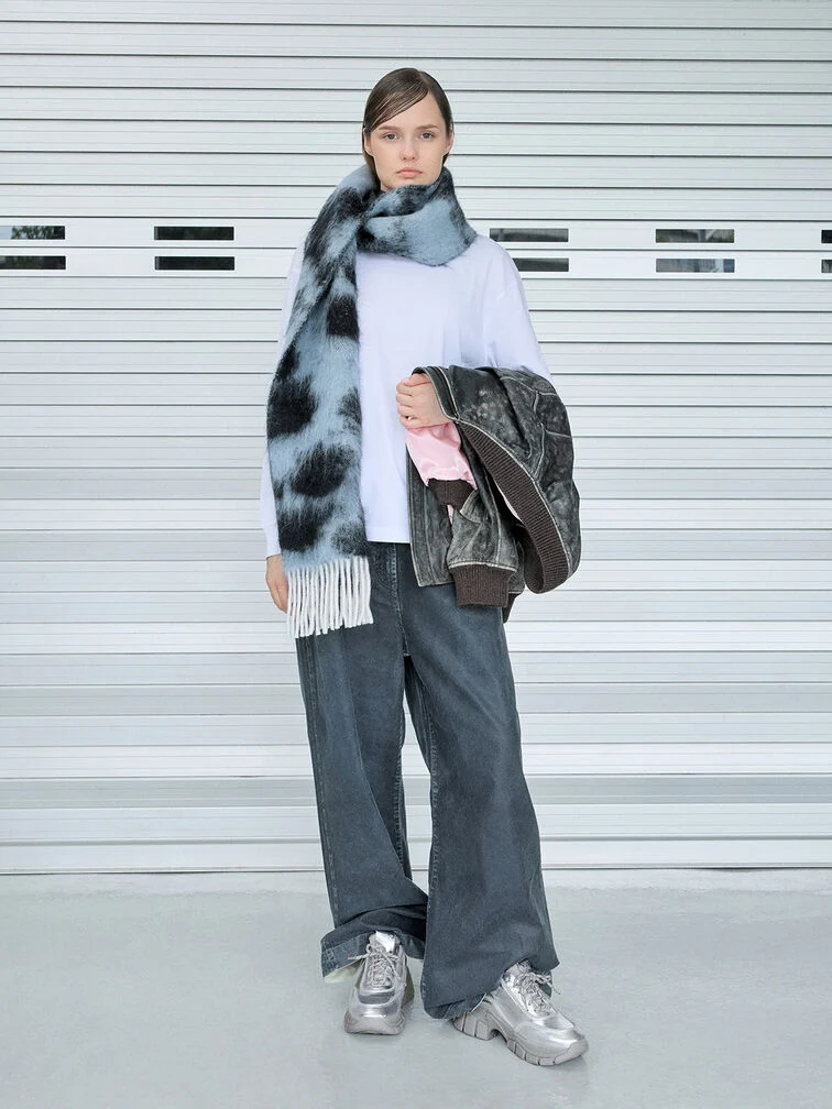 Metallic silver chunky sneakers, styled with an oversized t-shirt, wide-leg jeans and fringed scarf.