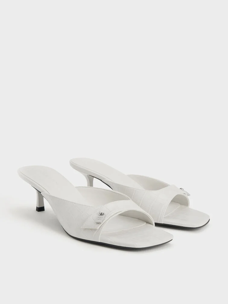 White croc-effect kitten-heel mules, an elegant option for year-end parties.