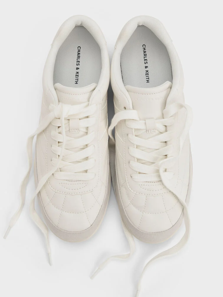 White low-profile trainers with refined details are a cool, stylish alternative to classic dress shoes for business-casual settings. 