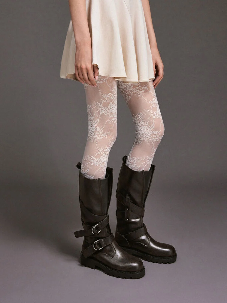 A mini dress styled with lace tights for an all-white outfit and paired with dark brown knee-high boots for a bold contrast. 