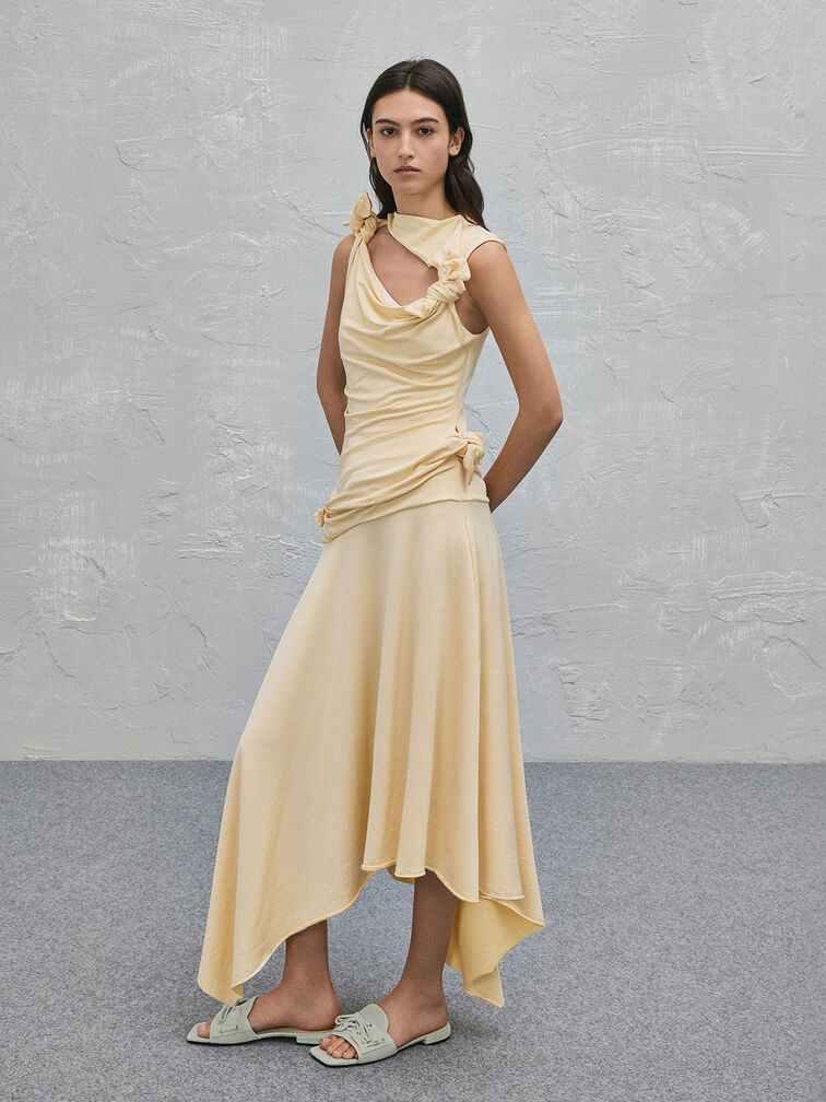 A yellow flowy maxi dress paired with mint-green slide sandals