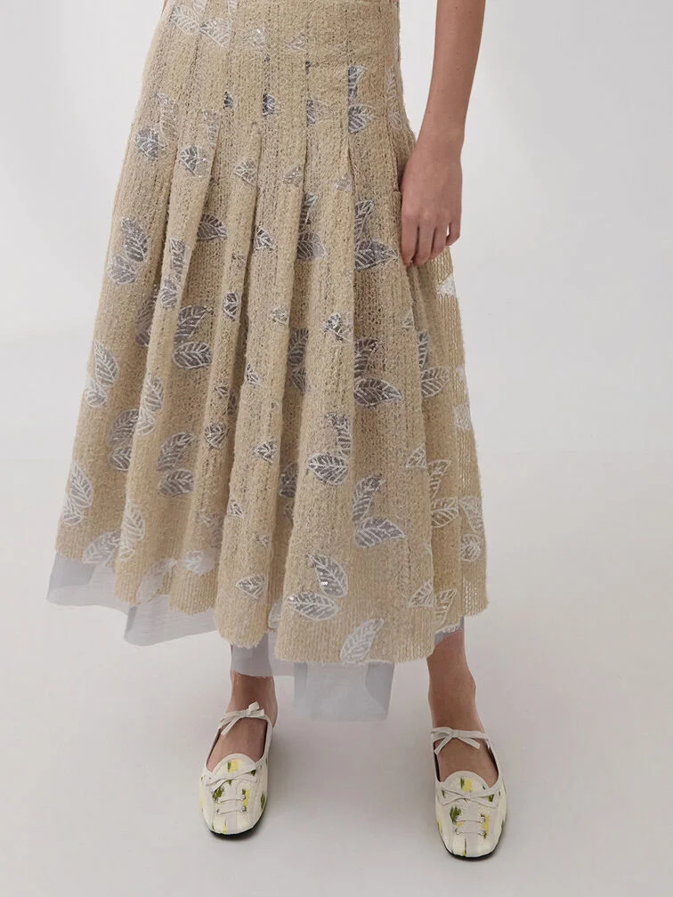 Jacquard skirt paired with floral-print mules. 