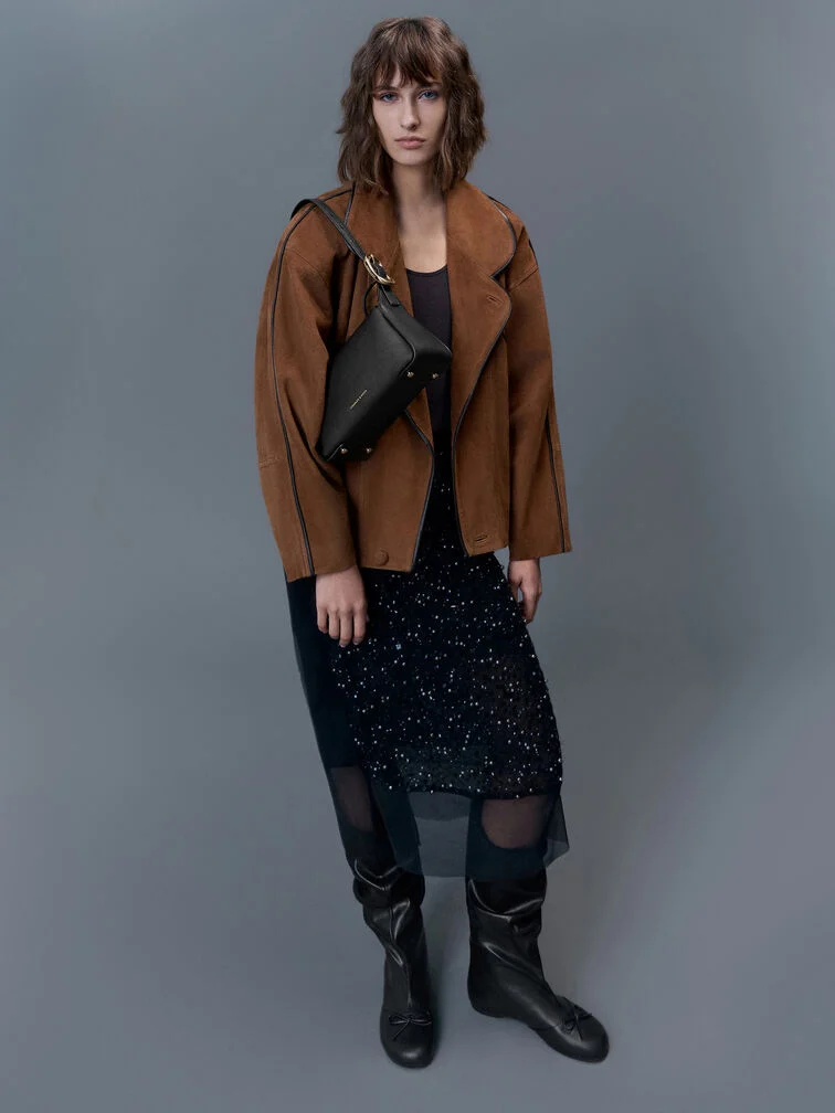 A loose blazer jacket layered over a black midi dress. 