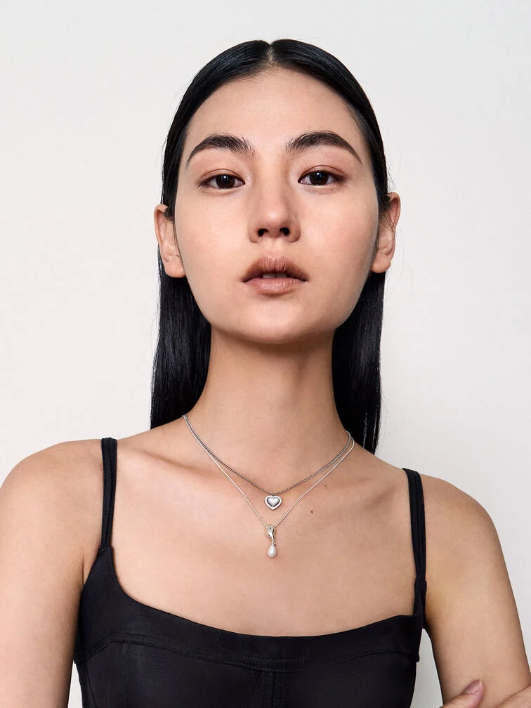 A two-layered necklace stack featuring different pendant sizes and drop length to create an elegant and fluid stack. 