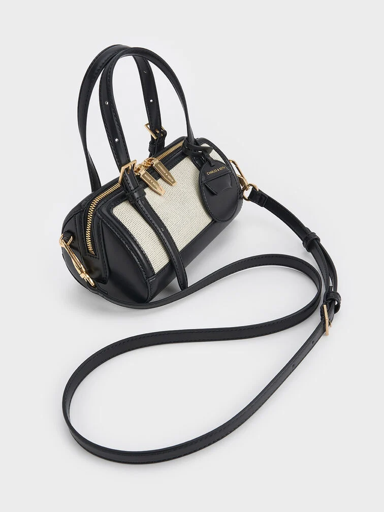 A bowling bag made with canvas, faux leather trims, handles, bag straps and metal hardware