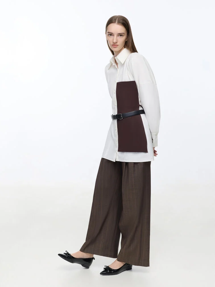 Black pointed-toe flats paired with flowy wide-leg trousers for a comfortable and work-ready look.