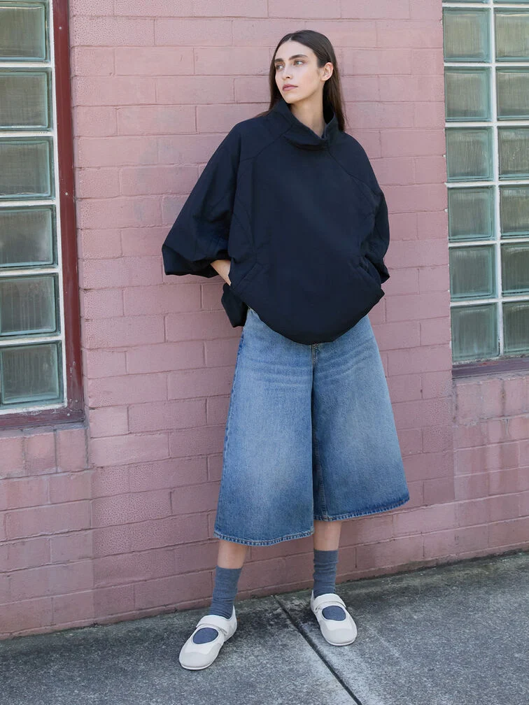 Mary Jane sneakers styled with socks, jorts and a windbreaker.