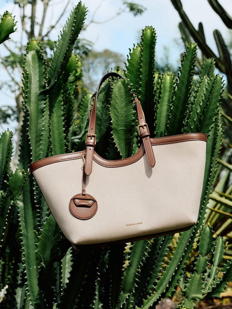 A canvas bag that features other non-canvas materials like contrast-trim handles made from faux leather
