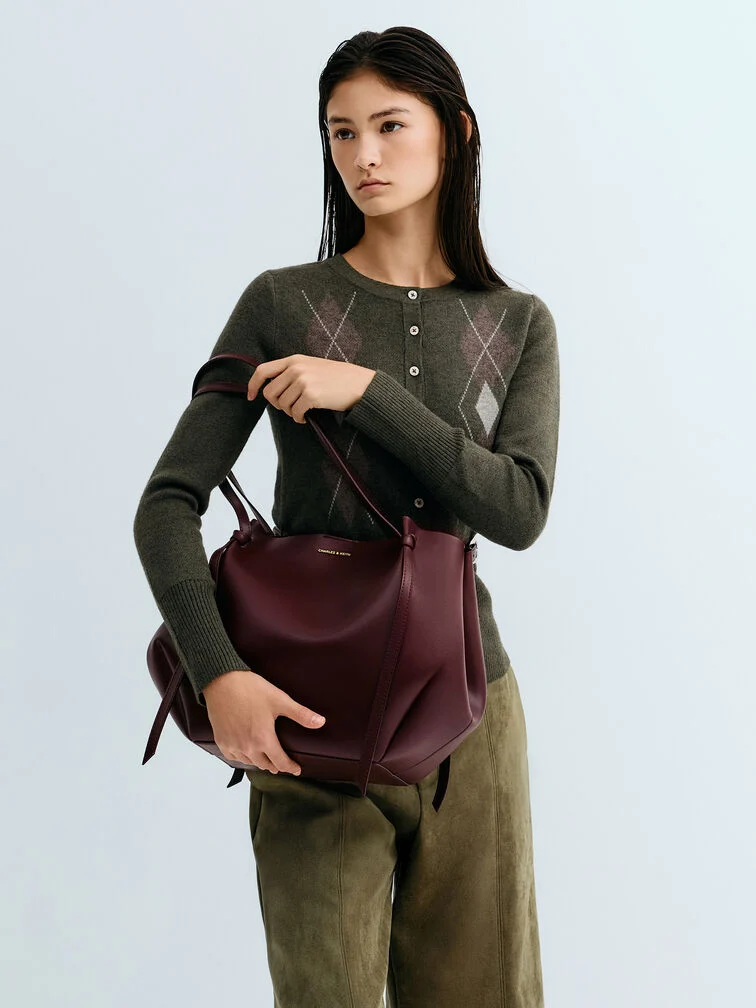 The XL Calla tote bag with its distinctive geometric shape and slim elongated handles.