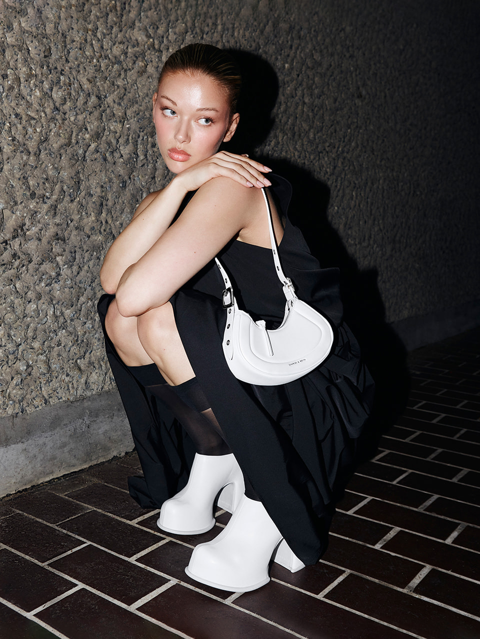 Women’s Petra curved shoulder bag and Pixie platform mules in white, as seen on Jessica Alexander - CHARLES & KEITH