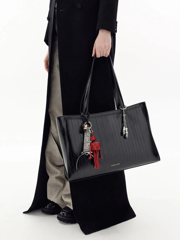 The lace-up and woven robot charms give the Augustine tote character.