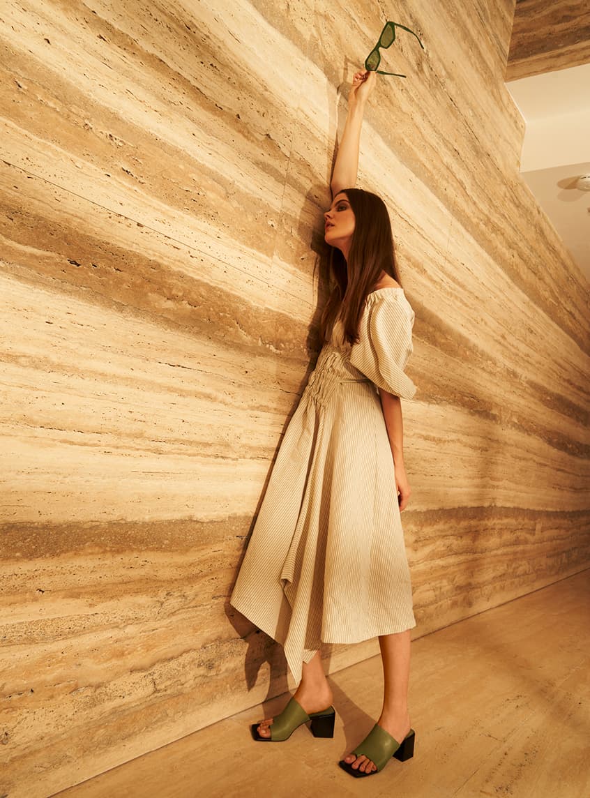 A model wearing a puff sleeve dress with square toe mules – standing up