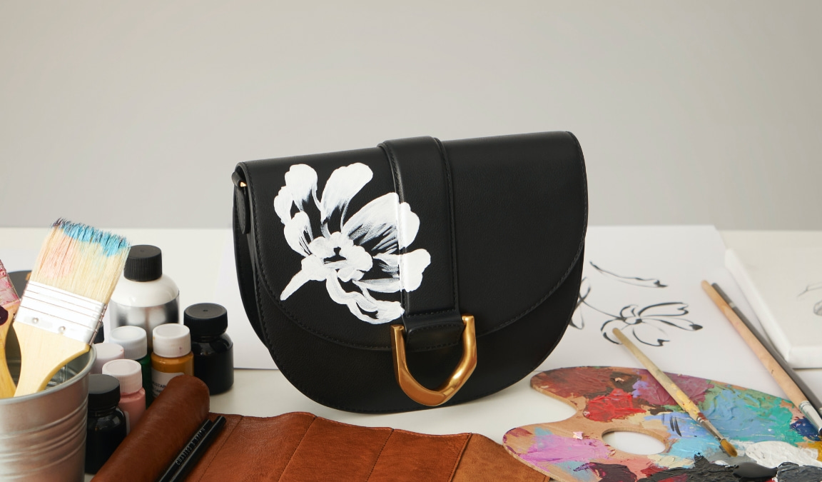 Hand-painted floral Gabine leather saddle bag in black - CHARLES & KEITH