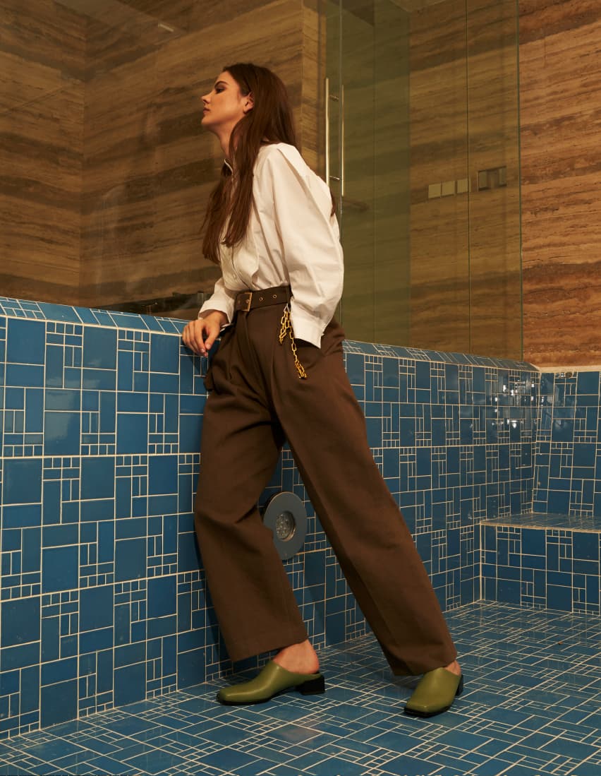 A model wearing tailored pants with square toe mules