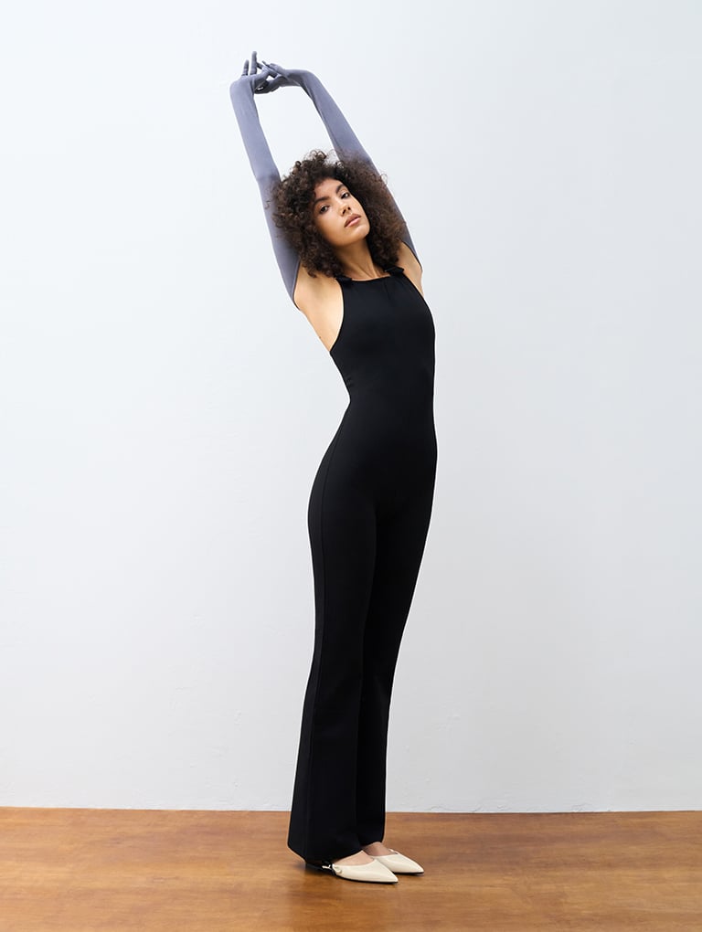 Women’s two-tone bow pointed-toe flats on model wearing a black maxi dress – CHARLES & KEITH