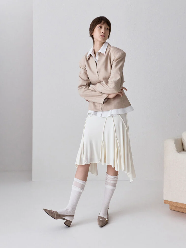 A monochromatic white outfit styled with neutral tones like beige and brown.
