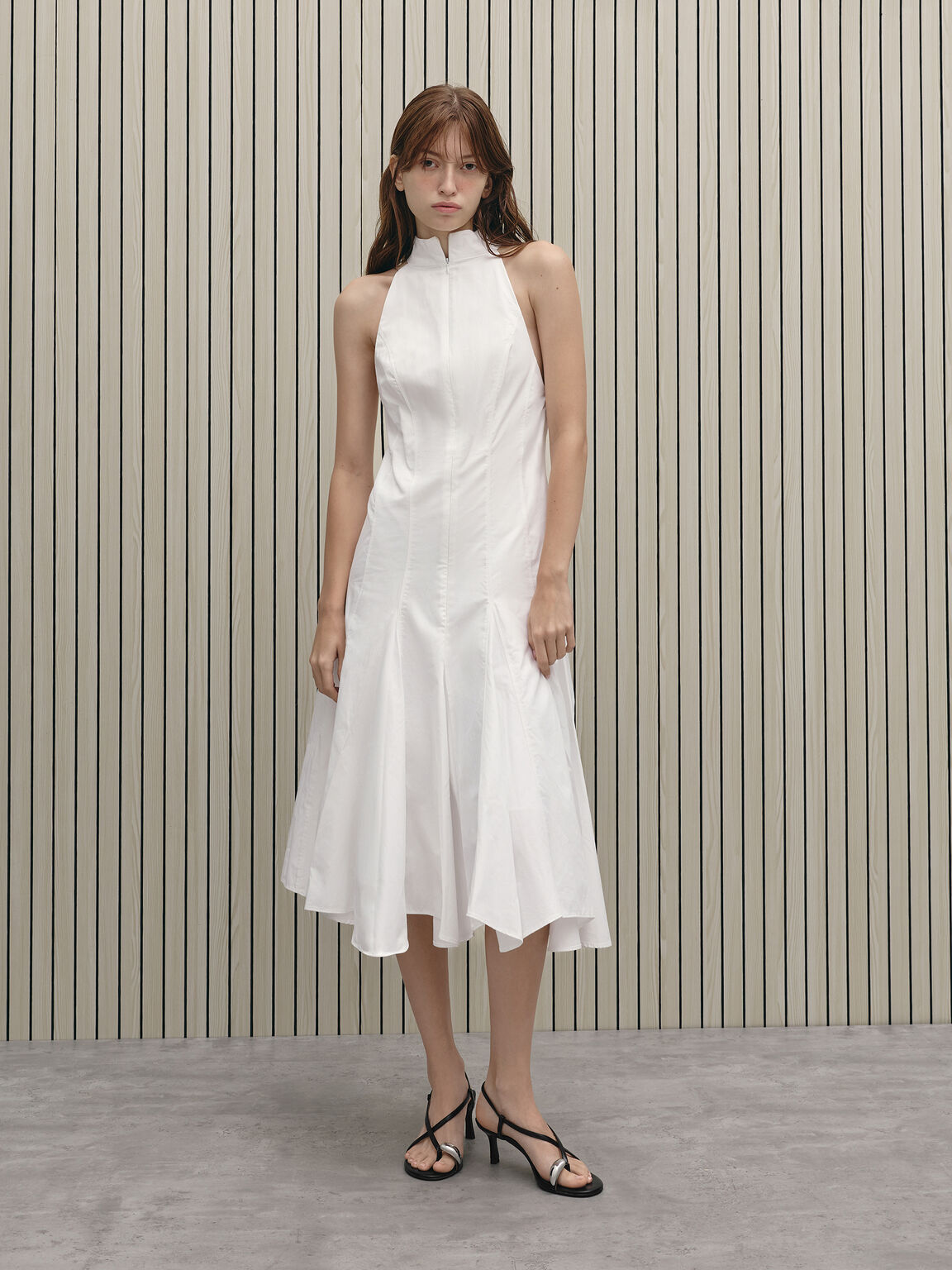 Black toe-ring heeled sandals styled with a white hanky hem midi dress.
