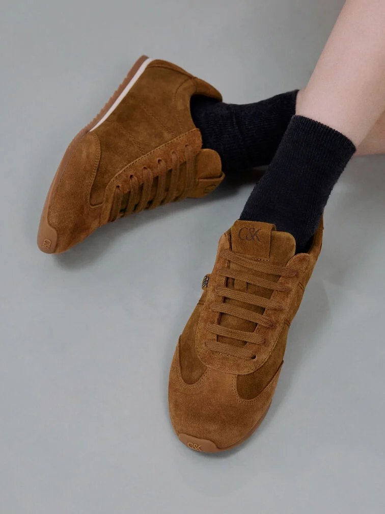 Low-profile brown suede trainers with a slim silhouette.
