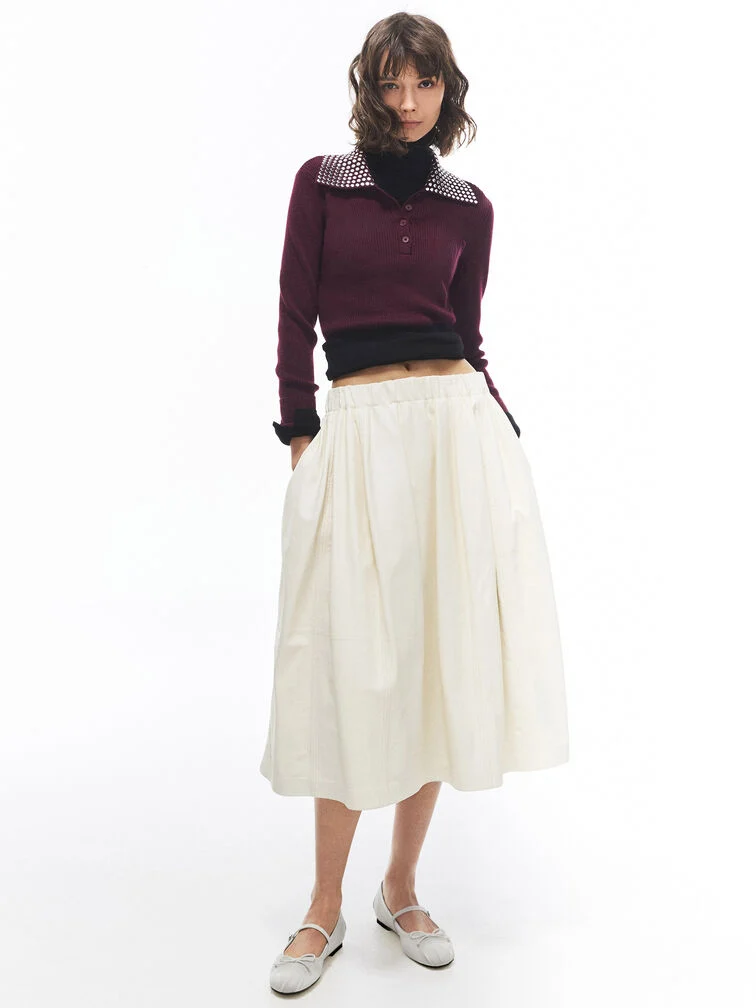 Round-toe Mary Jane flats styled with a casual-chic bubble-hem skirt and knitted long-sleeve top.