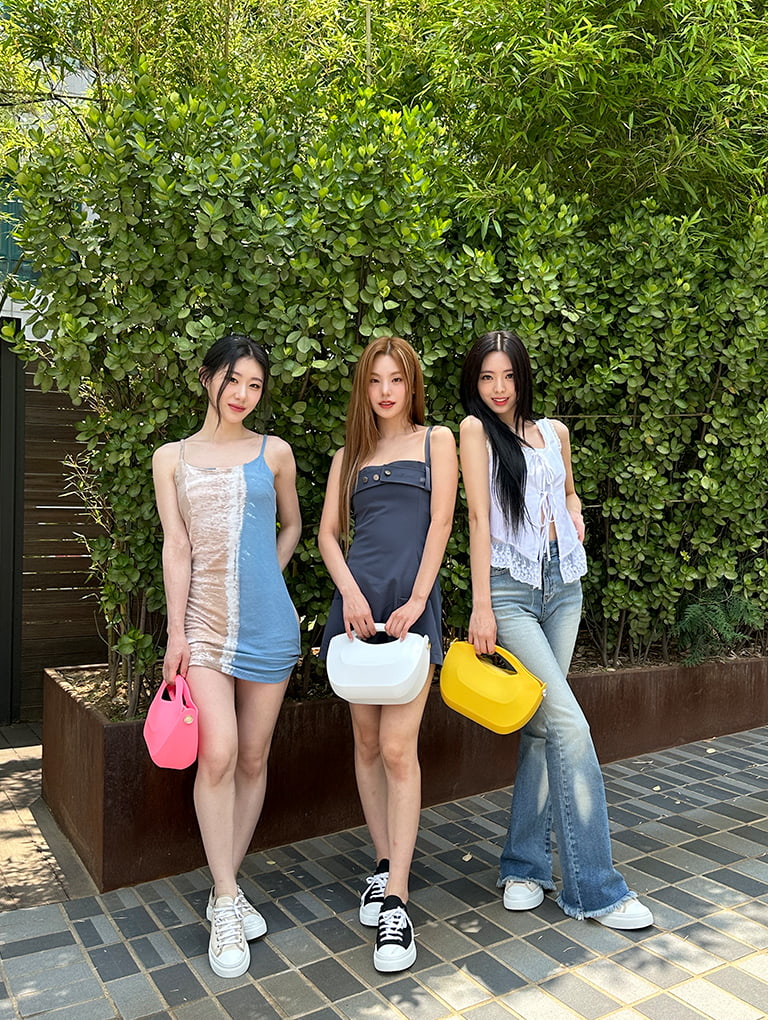 Women’s Cocoon Curved Handle Bag in pink, white, yellow; Canvas Low-Top Sneakers in black and taupe, as seen on Chaeyeong, Yeji and Yuna of ITZY - CHARLES & KEITH